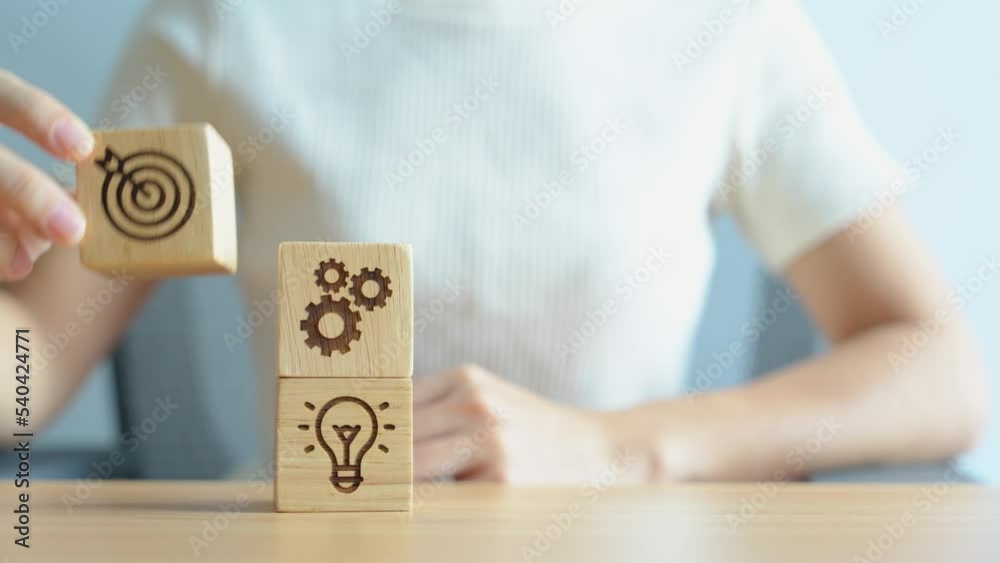 Woman hand holding dartboard above Gear and Lightbulb icon block. business planning process, goal, strategy, target, mission, action, objective, teamwork and idea concept