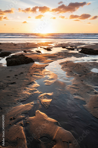 фотографія Stunning Summer sunset landscape image of Widemouth Bay in Devon England with go