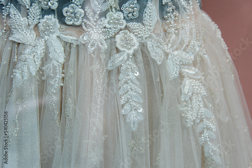 Beautiful bridal dress on hangers. Embroidery with beads. Wedding dress close up at the wedding salon. Wedding dresses hanging on a hanger