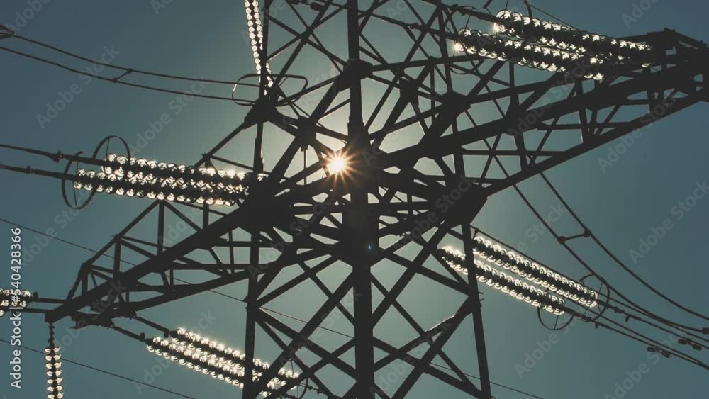 Power lines with sun rays on blue sky. High voltage substation. Electricity crisis in the world. Green energy in power lines. Selective soft focus Power lines with sun rays on blue sky. High voltage substation. Electricity crisis in the world. Green energy in power lines. Selective soft focus