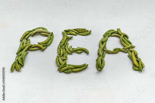 English alphabet of snap peas on white background. Letter P E N symbol made from sugar snap peas, Copy space for text, Selective Focus. photo