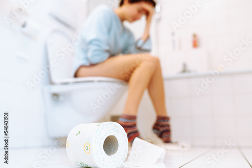 Sick, unhealthy woman, teenager, suffering from diarrhea, constipation and cystitis in toilet