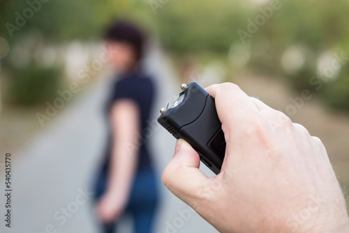 A man with a stun gun chases a woman to rob.