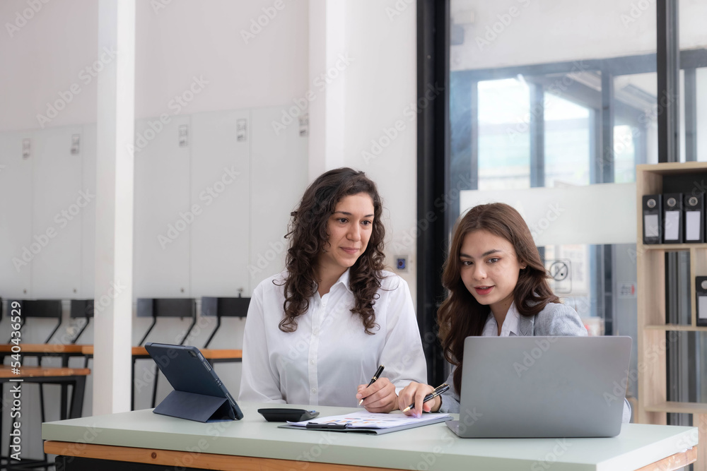 Two young Asian business woman talk, consult, discuss working with new startup project idea presentation analyze plan marketing and investment in the office. Two young Asian business woman talk, consult, discuss working with new startup project idea presentation analyze plan marketing and investment in the office.