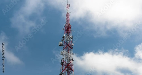 Transmission tower against fast moving clouds and blue sky