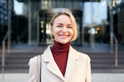 Middle-aged Caucasian businesswoman looking into camera smiles.Beautiful 40-50 years old cheerful lady smiling for the successes of work. High quality photo photo