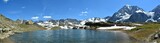 Panoramic view of a lake surrounded by snowy Ortler mountains in Sulden, South Tyrol, Italy