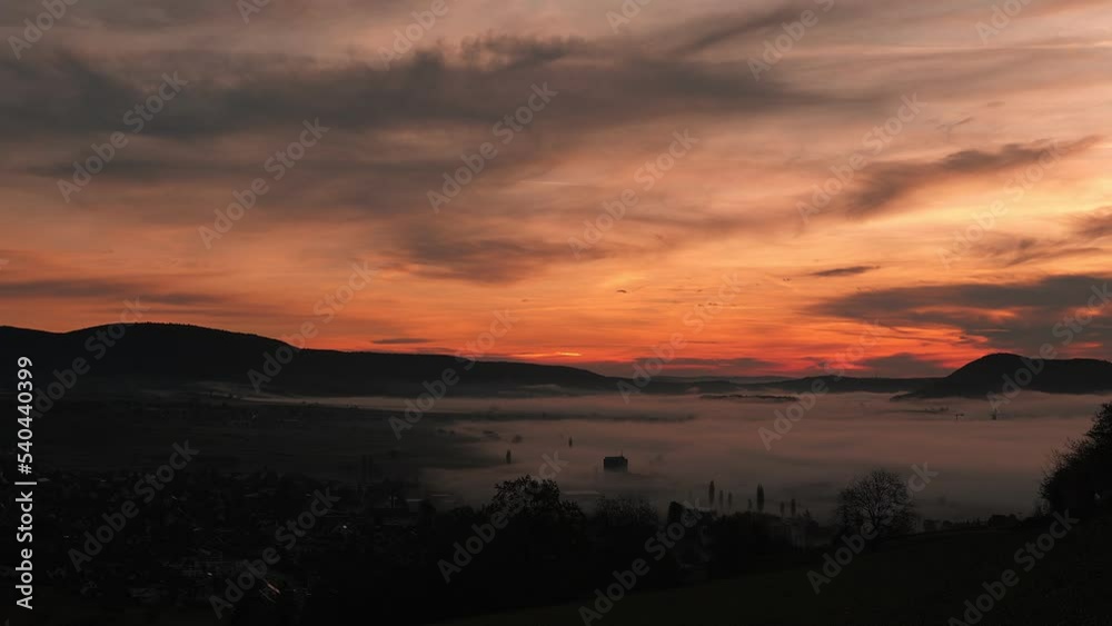 Orange purple sunrise over mountains with fog mist. Morning mist at sunrise