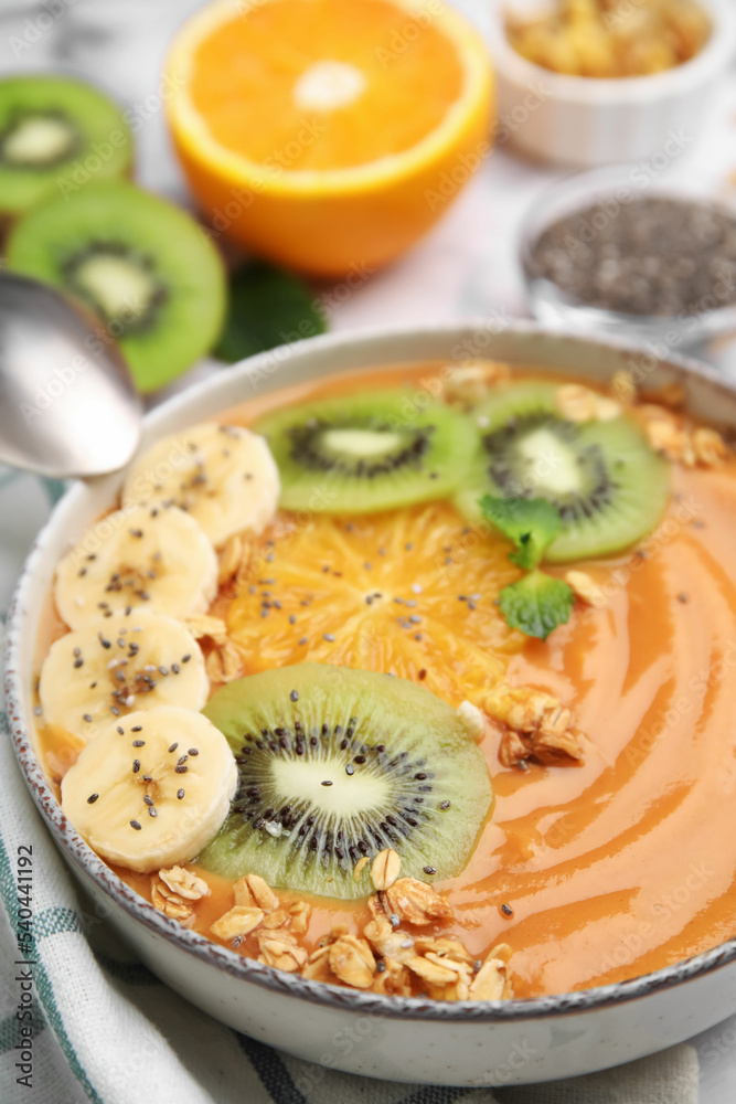 Bowl of delicious fruit smoothie with fresh banana, kiwi slices and granola served on white table, closeup Bowl of delicious fruit smoothie with fresh banana, kiwi slices and granola served on white table, closeup