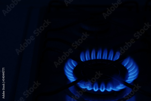Gas burner with burning flame in darkness. Space for text