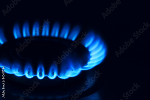 Gas burner with burning flame in darkness, closeup