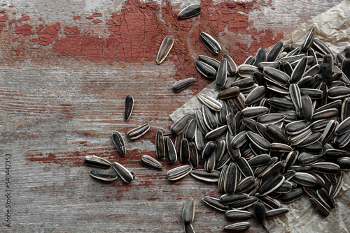 Pile of sunflower seeds on wooden table, flat lay. Space for text