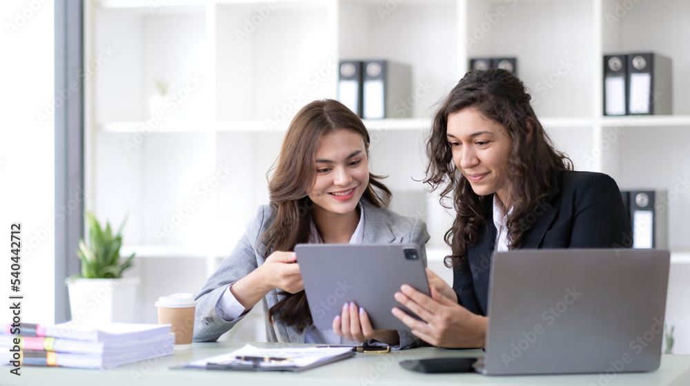 Two young Asian business woman talk, consult, discuss working with new startup project idea presentation analyze plan marketing and investment in the office. Two young Asian business woman talk, consult, discuss working with new startup project idea presentation analyze plan marketing and investment in the office.