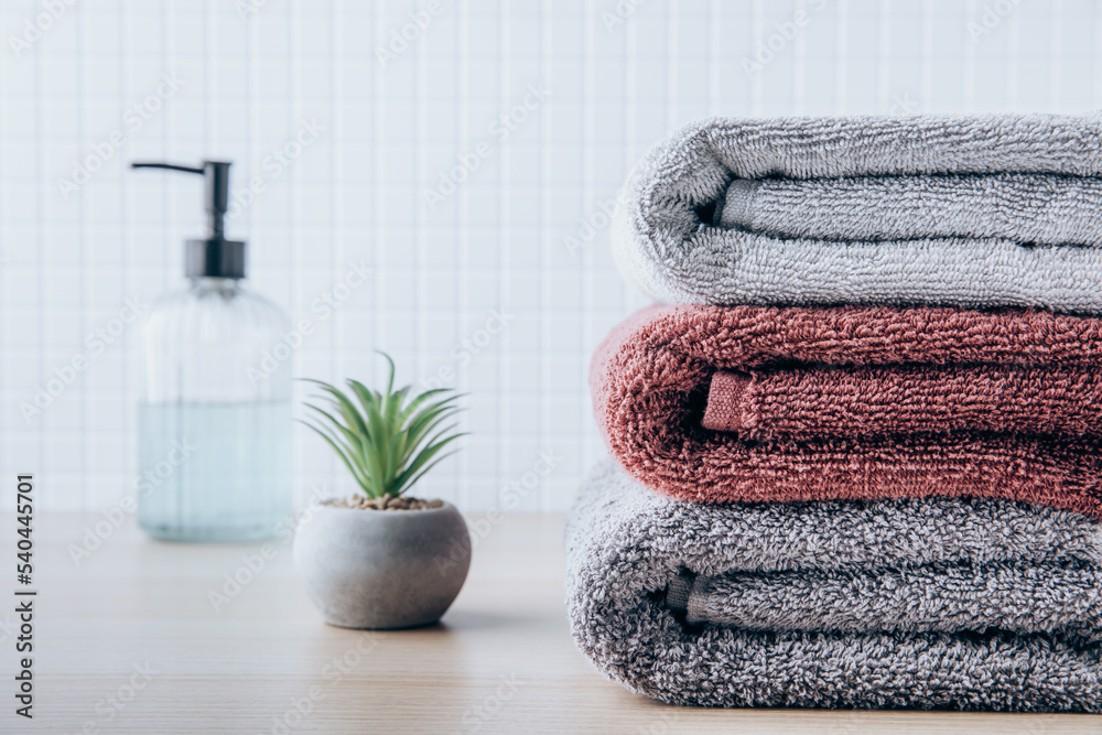 Towels. Clean fresh fluffy towels and bath accessories on table in bathroom  Stock Photo