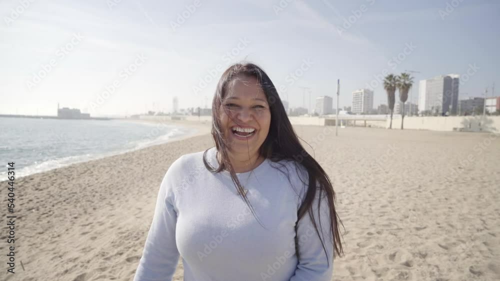 Happy middle-aged woman laughs it off looking at camera outdoors on the beach. Happy people enjoying life. Positive emotions of a confident lady. High quality 4k footage Happy middle-aged woman laughs it off looking at camera outdoors on the beach. Happy people enjoying life. Positive emotions of a confident lady. High quality 4k footage