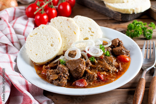 Beef goulash and dumplings (knedliky) on table from Czech Republic
