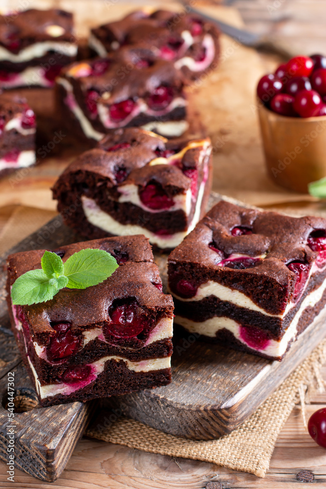 Brownie with cottage cheese and cherries on wooden table