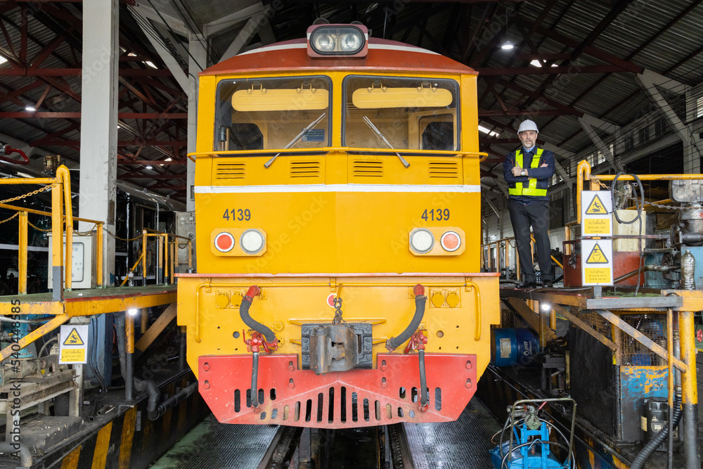 Portrait of Engineer in the process of inspecting train engines
