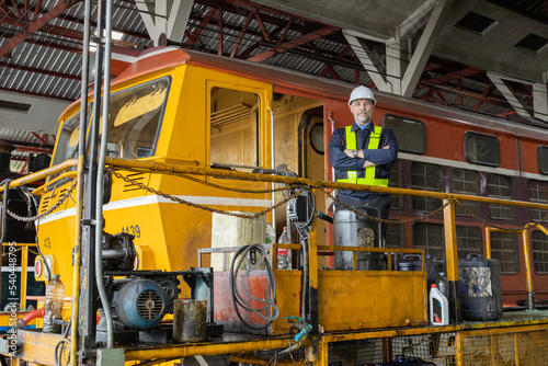 Portrait of Engineer in the process of inspecting train engines 