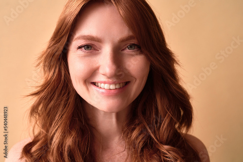 Fotografi Close-up portrait of a beautiful woman with red hair smiling.