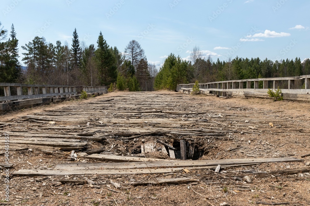 Old wooden dilapidated bridge with dips Old wooden dilapidated bridge with dips