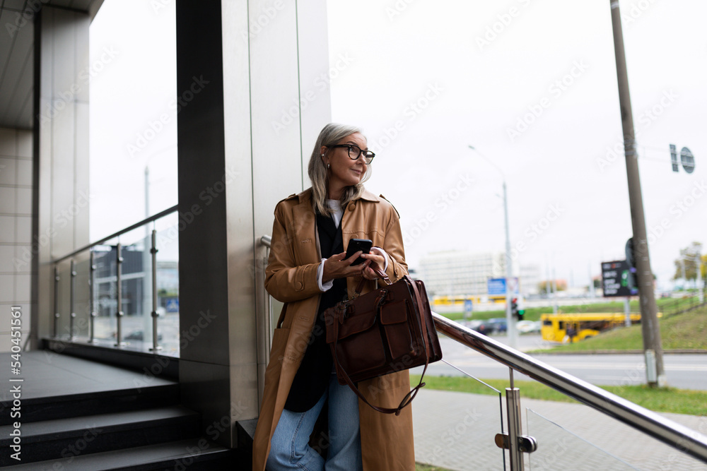 Obraz premium 50 year old female lawyer waiting for a client for a meeting near the business center