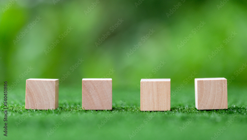 Stacking blank wooden cubes on green background with copy space for input wording and infographic icon. Empty brown wooden object block for symbol icon put technology, zero gravity, business concept. Stacking blank wooden cubes on green background with copy space for input wording and infographic icon. Empty brown wooden object block for symbol icon put technology, zero gravity, business concept.