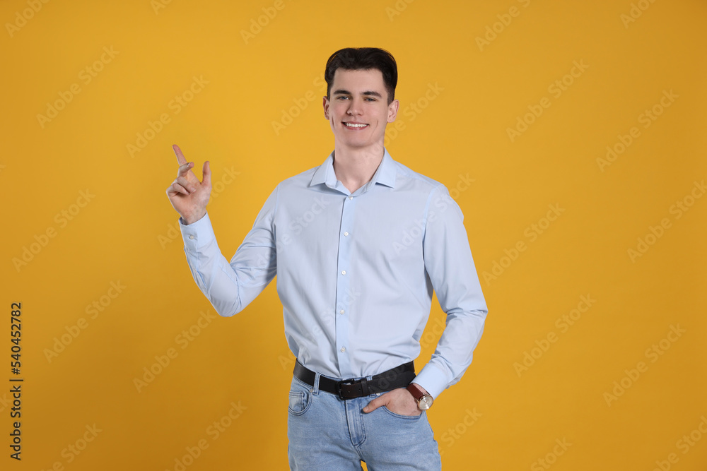 Portrait of handsome young man gesturing on yellow background Portrait of handsome young man gesturing on yellow background