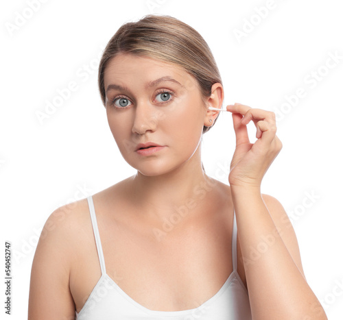 Young woman cleaning ear with cotton swab on white background