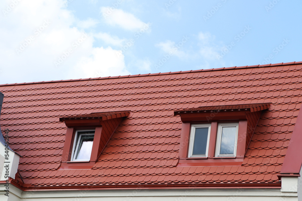 View of beautiful house with brown roof against cloudy sky