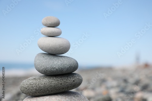 Stack of stones on beach against blurred background  closeup. Space for text