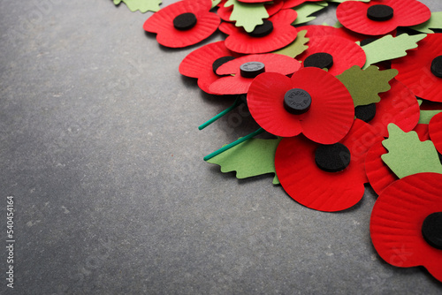 World War remembrance day. Red paper poppies on dark stone background