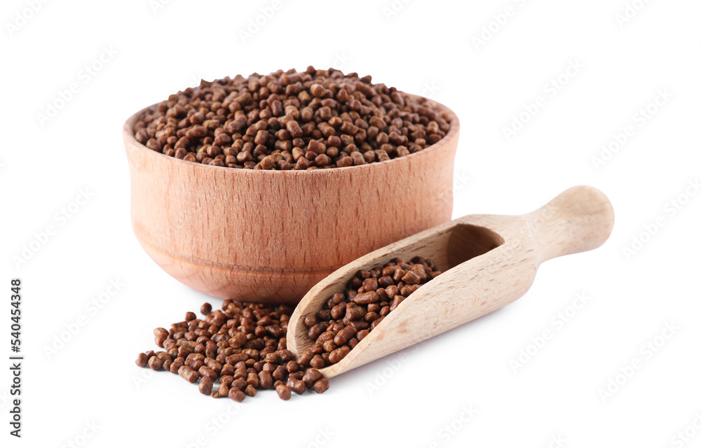 Wooden bowl and scoop with buckwheat tea granules white background Wooden bowl and scoop with buckwheat tea granules white background
