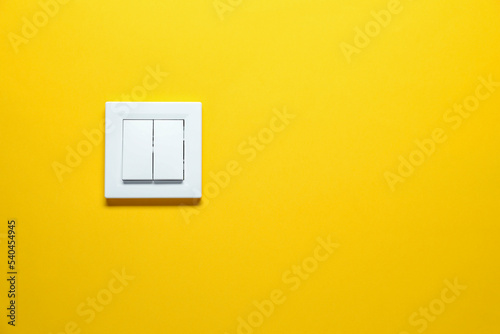 Modern plastic light switch on orange background. Space for text photo