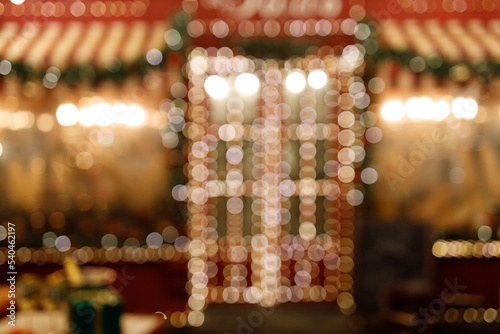 Blurry house decorated with garlands in the New Year's style. Beautiful Christmas background from bokeh.