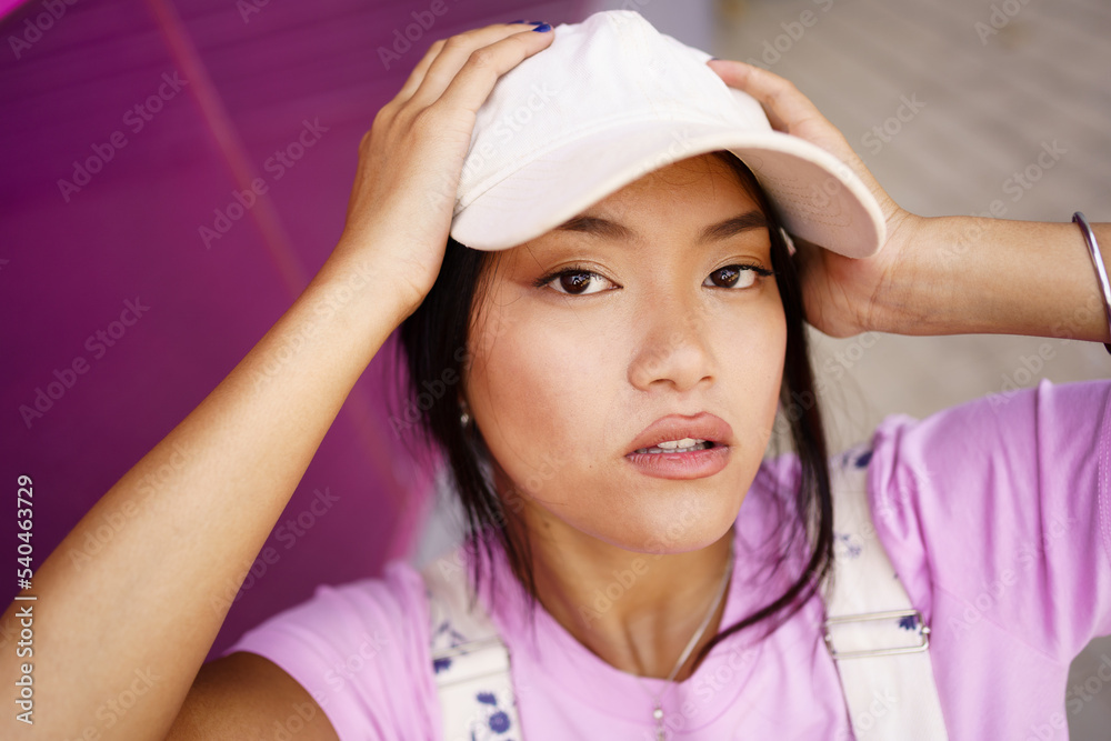 Asian girl taking a photo or video selfie with her smartphone, to post on social media.