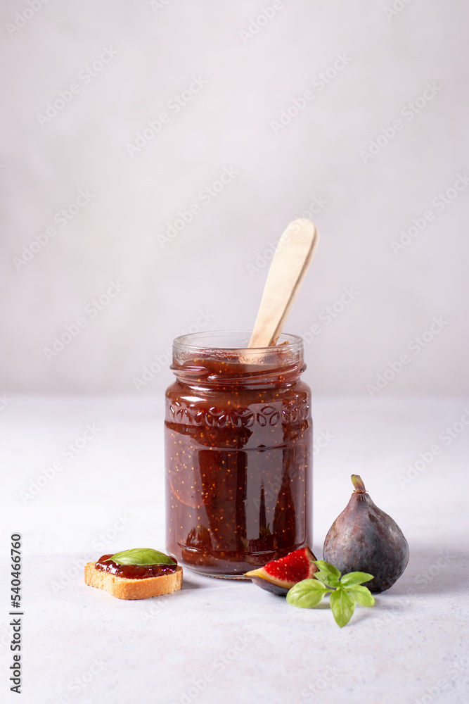 Fototapeta premium Fig jam or fig marmalade on wooden board with fresh, ripe figs