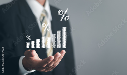 Concept of financial interest rates and mortgage rates. Businessman showing percentage icon with graph indicator. Interest rate, stocks, financial, ranking, mortgage rates.