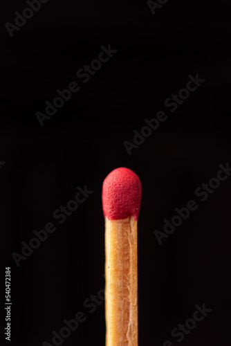 Matchstick in detail seen through a macro lens, black background, selective focus.