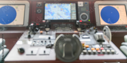 Navigational control panel and VHF radio. Working on the ship's navigational bridge. Blurred image. © Alexey Seafarer