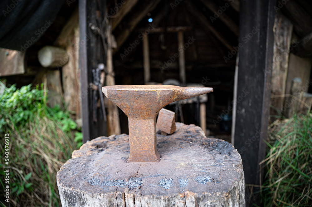 Anvil in front of a medieval blacksmith's hut Anvil in front of a medieval blacksmith's hut