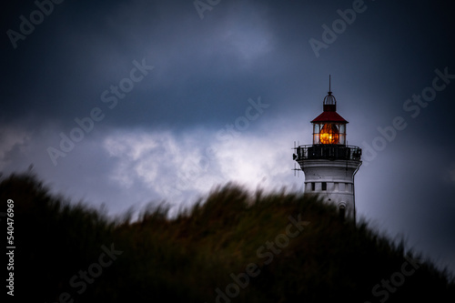 Nørre Lyngvig lighthouse behind a dune during a storm