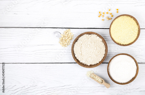 An assortment of alternative, gluten-free flours. Baking ingredients background: gluten free rice, corn, oatmeal on a white wooden background,. Copy space, top view.