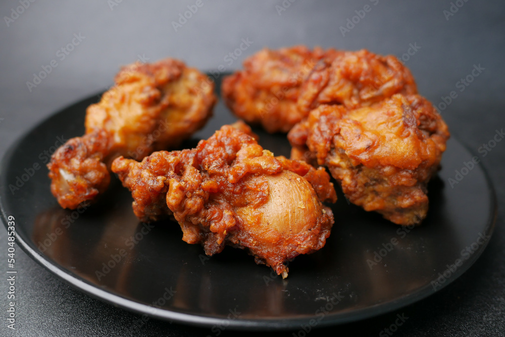 fried chicken fillets on plate on black background fried chicken fillets on plate on black background