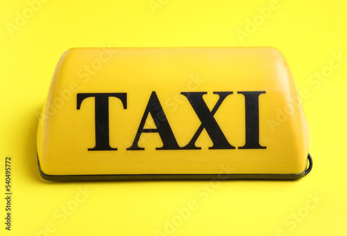Taxi roof sign on yellow ba...