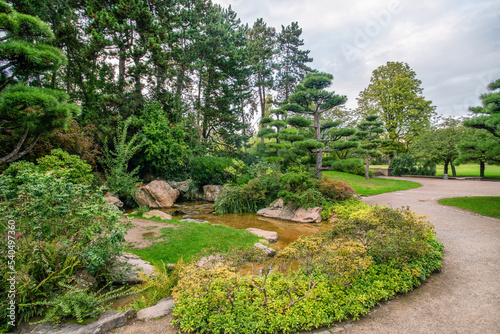 Japanese garden in NORDPARK in Dusseldorf with artificial stream and topiary pine trees and rocks © Marat Lala