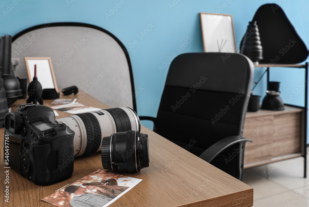 Fototapeta premium Professional photo camera and picture on table in studio, closeup
