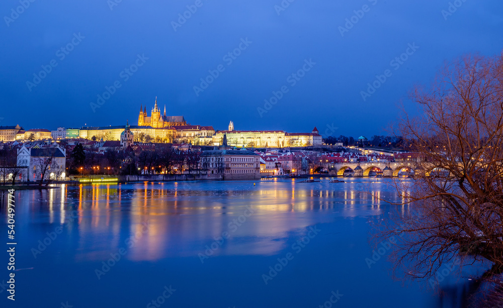 Amazing illuminated Prague Castle and reflection in water and Charles bridge  in blue hour