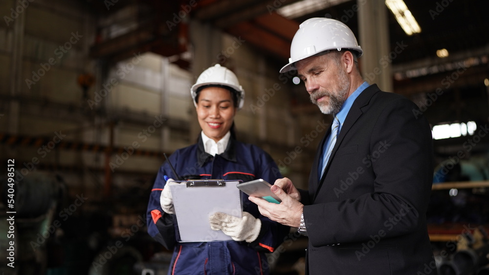Factory manager or businessman and female engineer in factory. elegant man inspecting factory in industry plant background. Factory manager or businessman and female engineer in factory. elegant man inspecting factory in industry plant background.
