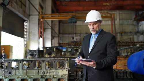 Factory manager or businessman and female engineer in factory. elegant man inspecting factory in industry plant background.